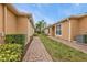 Brick paved walkway between houses, lush green grass and tropical plants at 4590 Turnberry Cir, North Port, FL 34288