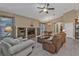 Living room with comfy seating, built-in shelves, and a large TV at 4590 Turnberry Cir, North Port, FL 34288