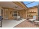 Covered patio with table, chairs, and grill. Features a ceiling fan and access to the interior at 4590 Turnberry Cir, North Port, FL 34288