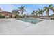 Community pool with plenty of lounge chairs and palm trees at 4590 Turnberry Cir, North Port, FL 34288