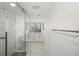 Bathroom featuring a glass-enclosed shower, modern vanity, marble tile floor, and natural light at 5220 Landings Blvd # 104, Sarasota, FL 34231