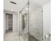 Bathroom featuring a modern glass-enclosed shower, marble-look tile floor, and walk in closet at 5220 Landings Blvd # 104, Sarasota, FL 34231