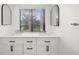 Bathroom featuring a double sink vanity with white cabinets, modern fixtures, and a large window at 5220 Landings Blvd # 104, Sarasota, FL 34231