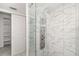 Bathroom featuring modern shower with glass, marble-look tile, and a sliding door to walk-in closet at 5220 Landings Blvd # 104, Sarasota, FL 34231