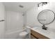 Stylish bathroom featuring subway tile shower, modern fixtures, and sleek vanity with round mirror at 5220 Landings Blvd # 104, Sarasota, FL 34231