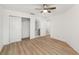 Bright bedroom with closet, ceiling fan, and ensuite bathroom with modern wood-look vinyl floors at 5220 Landings Blvd # 104, Sarasota, FL 34231