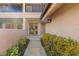 Welcoming entrance featuring a tiled walkway with colorful landscaped foliage leading to a sliding glass door at 5220 Landings Blvd # 104, Sarasota, FL 34231