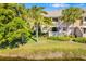 Townhome with a patio and tropical landscaping overlooking a pond at 5220 Landings Blvd # 104, Sarasota, FL 34231