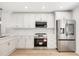Well-lit kitchen with sleek stainless steel appliances, white cabinets, and modern backsplash at 5220 Landings Blvd # 104, Sarasota, FL 34231