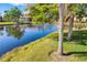 Scenic pond with a fountain, surrounded by lush green lawns and mature palm trees at 5220 Landings Blvd # 104, Sarasota, FL 34231