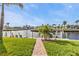 Brick pathway leads to the private dock on a tranquil canal surrounded by tropical landscaping at 805 Via Formia, Punta Gorda, FL 33950