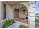 Inviting front entrance with double glass doors, decorative palm tree wall art, and a brick tiled porch at 805 Via Formia, Punta Gorda, FL 33950