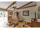 Inviting living room with wooden ceiling beams, comfortable chairs, and vibrant rug at 805 Via Formia, Punta Gorda, FL 33950