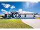 Beautiful home featuring a metal roof, attached three-car garage, manicured lawn and tasteful landscaping at 1052 Eppinger Dr, Port Charlotte, FL 33953