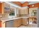 Sunlit kitchen featuring stainless steel appliances, tile backsplash, and cream-colored cabinets at 1164 Harbor Town Way, Venice, FL 34292