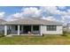 Single-story home with covered patio, grassy backyard, and tasteful landscaping at 12717 Morning Mist Pl, Venice, FL 34293