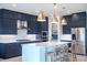 Stylish kitchen featuring blue cabinetry, a large island, and gold lighting at 12717 Morning Mist Pl, Venice, FL 34293