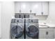 Laundry room with modern washer and dryer, cabinets, and countertop space at 12717 Morning Mist Pl, Venice, FL 34293