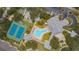Aerial view of the community featuring a pool, clubhouse, tennis courts, bocce ball court, parking, and lush landscaping at 1407 Red Oak Ln, Port Charlotte, FL 33948