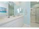 Bathroom with double sink, white cabinets, light blue walls and walk-in shower at 1407 Red Oak Ln, Port Charlotte, FL 33948
