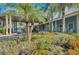 Lush landscaping surrounds the clubhouse, with golf cart parking and inviting rocking chairs at 1407 Red Oak Ln, Port Charlotte, FL 33948