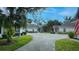 Community of homes with a long shared driveway and lush tropical landscaping and well-maintained lawns at 1407 Red Oak Ln, Port Charlotte, FL 33948