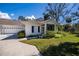 Charming single-story home with a well-manicured front yard and an attached two-car garage at 1407 Red Oak Ln, Port Charlotte, FL 33948
