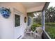 Inviting front porch with seating, decorative floral arrangement, and view of the greenery at 1407 Red Oak Ln, Port Charlotte, FL 33948
