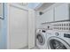 Well-equipped laundry room with a washer and dryer and a large white door at 1407 Red Oak Ln, Port Charlotte, FL 33948