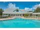 Beautiful pool with a view of the clubhouse, surrounded by lounge chairs and lush landscaping at 1407 Red Oak Ln, Port Charlotte, FL 33948