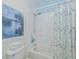 Shower with a curtain, white tiles, and a blue and white color scheme at 1407 Red Oak Ln, Port Charlotte, FL 33948