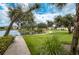 Scenic community walking path winding alongside a tranquil lake and lush landscaping at 1407 Red Oak Ln, Port Charlotte, FL 33948