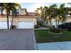 Two-story home's exterior features a brick driveway, attached garage, and lush landscaping at 141 Tropicana Dr # 1111, Punta Gorda, FL 33950