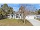 Single-story house with a gray roof, white garage door, and landscaped lawn at 1418 Purple Ln, North Port, FL 34286