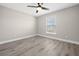 Bedroom featuring light gray walls, wood-look flooring, a ceiling fan and a window allowing natural light at 16031 Hesta Misty Ct, Punta Gorda, FL 33955