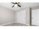 Bedroom featuring light gray walls, wood-look flooring, a ceiling fan and a double door closet at 16031 Hesta Misty Ct, Punta Gorda, FL 33955