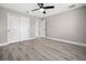 Bedroom featuring light gray walls, wood-look flooring, a ceiling fan and a double door closet at 16031 Hesta Misty Ct, Punta Gorda, FL 33955