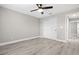 Bedroom featuring light gray walls, wood-look flooring, a ceiling fan and a double door closet at 16031 Hesta Misty Ct, Punta Gorda, FL 33955