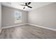 Bedroom featuring light gray walls, wood-look flooring, a ceiling fan and a window allowing natural light at 16031 Hesta Misty Ct, Punta Gorda, FL 33955
