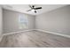 Bedroom featuring light gray walls, wood-look flooring, a ceiling fan and a window allowing natural light at 16031 Hesta Misty Ct, Punta Gorda, FL 33955