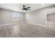 A spacious bedroom features wood-style flooring, a ceiling fan, and natural light from the window at 16031 Hesta Misty Ct, Punta Gorda, FL 33955