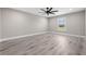 A spacious bedroom features wood-style flooring, a ceiling fan, and natural light from the window at 16031 Hesta Misty Ct, Punta Gorda, FL 33955