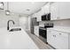 Kitchen featuring stainless steel appliances, white cabinets, quartz countertops, and hardwood floors at 16031 Hesta Misty Ct, Punta Gorda, FL 33955
