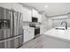 Kitchen featuring stainless steel appliances, white cabinets, quartz countertops, and hardwood floors at 16031 Hesta Misty Ct, Punta Gorda, FL 33955