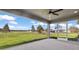 Covered patio overlooking a green lawn and neighborhood with a ceiling fan and screened-in walls at 16031 Hesta Misty Ct, Punta Gorda, FL 33955