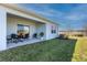 Covered patio with seating area and grassy backyard at 16255 Lady Palm Dr, Port Charlotte, FL 33953