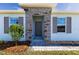 Inviting front entry with stone accents and gray front door at 16255 Lady Palm Dr, Port Charlotte, FL 33953