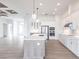 Open concept kitchen with white cabinets, large island and stainless steel appliances at 16920 Ohara Dr, Port Charlotte, FL 33948