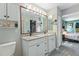 Double vanity bathroom with granite countertops and access to bedroom at 17455 Boca Vista Rd, Punta Gorda, FL 33955