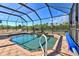 Relaxing pool with a waterfall feature and screened enclosure at 17455 Boca Vista Rd, Punta Gorda, FL 33955